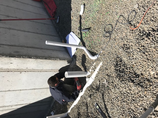 Aaron's Plumbing technician installing underground PVC drain lines at a job site